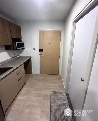 Modern compact kitchen with sleek cabinetry and microwave