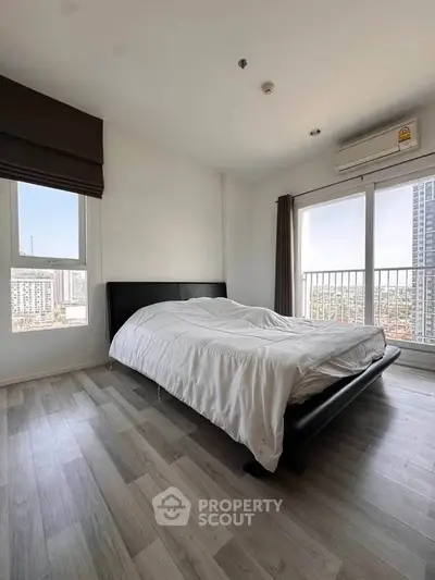 Spacious bedroom with modern design and city view in high-rise apartment