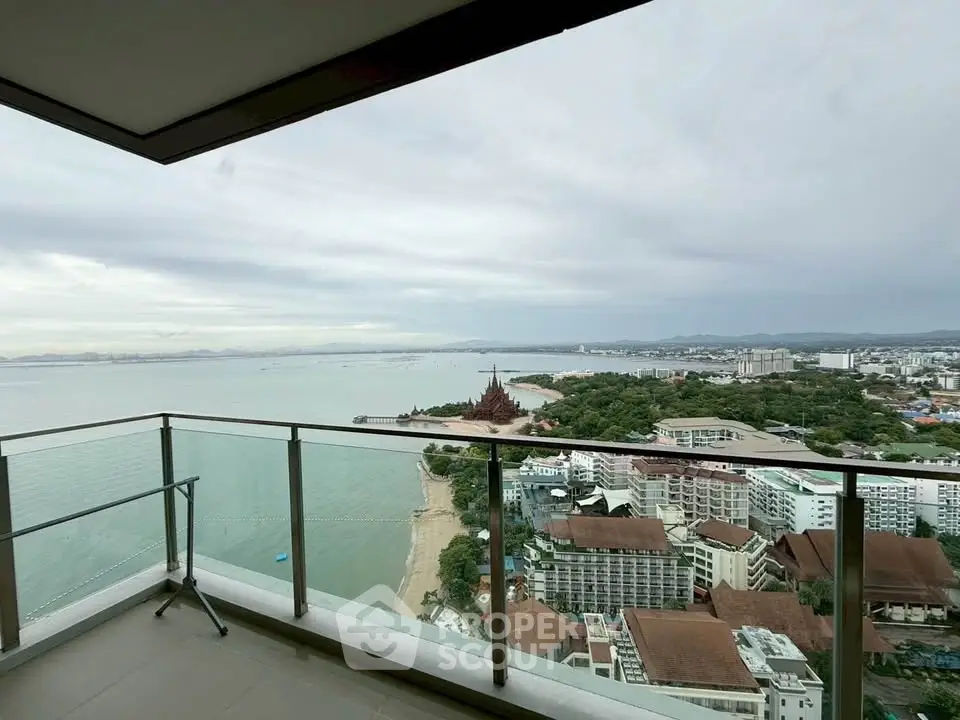 Stunning high-rise balcony view overlooking the ocean and cityscape, perfect for luxury living.