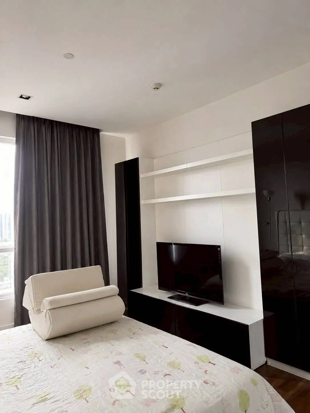 Modern bedroom with sleek TV unit and large window for natural light