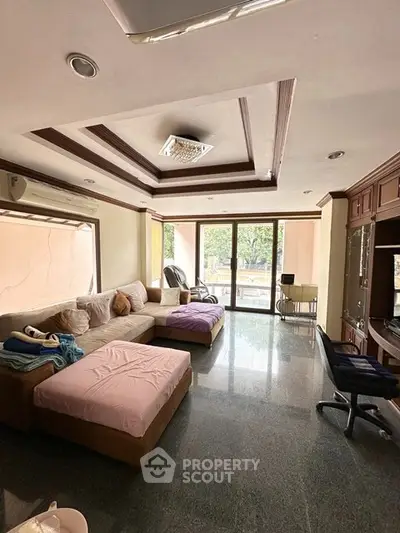 Spacious living room with large windows and modern furniture in a stylish apartment.