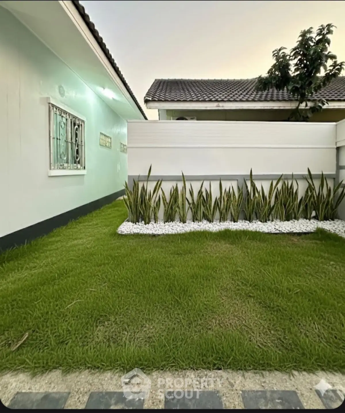 Charming suburban home with lush green lawn and modern exterior design.