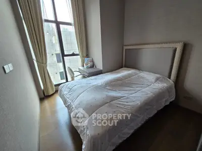 Cozy bedroom with large window and modern decor in a stylish apartment