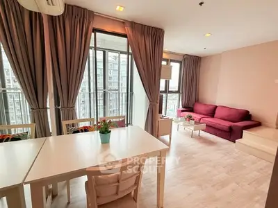 Spacious living room with modern decor and large windows offering city views.