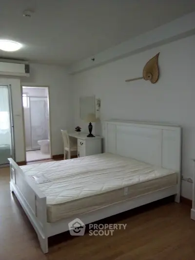 Spacious bedroom with ensuite bathroom in modern apartment