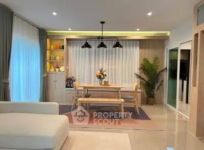 Modern living room with stylish dining area, cozy seating, and elegant decor in a bright, open space.