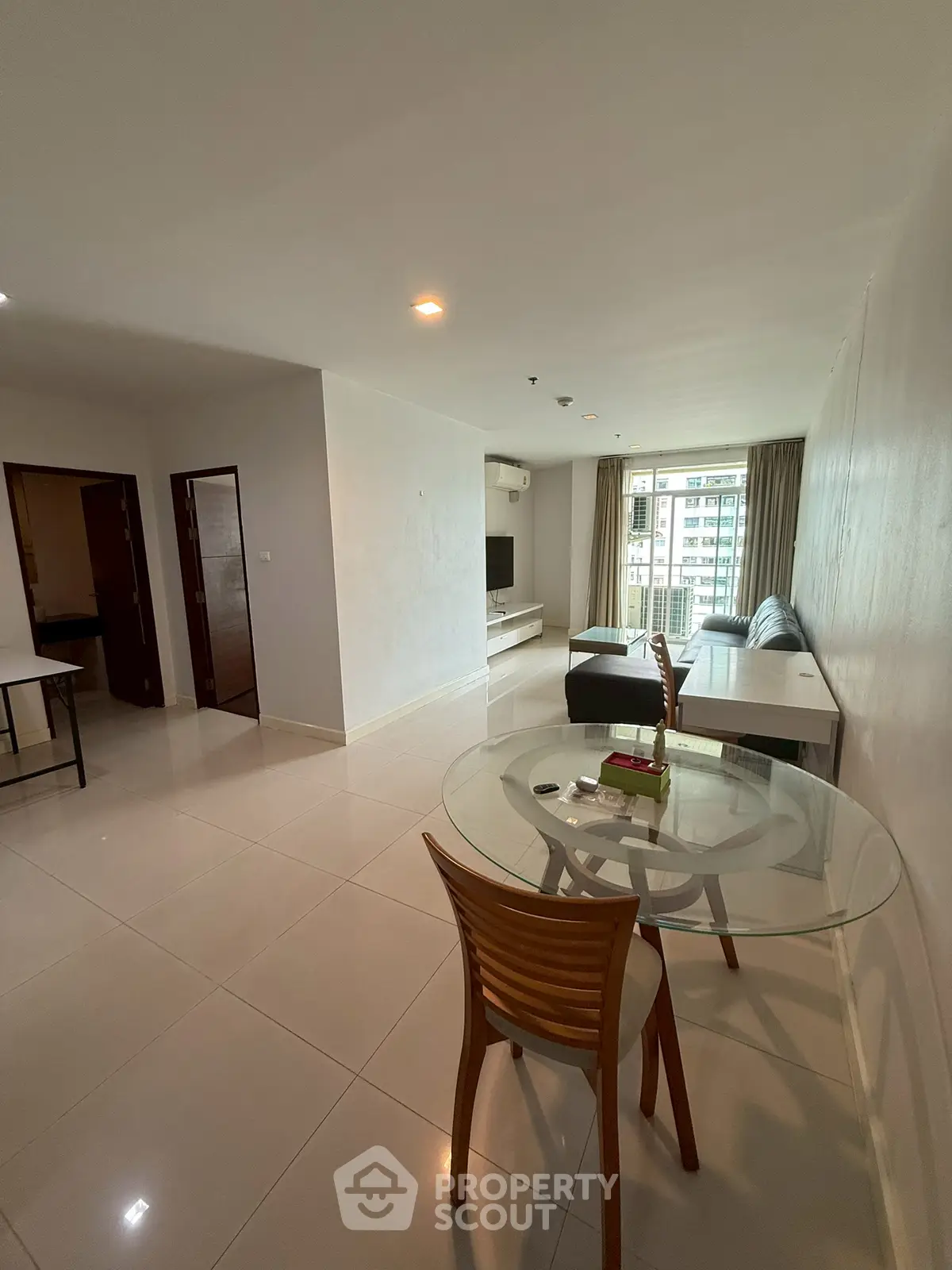 Spacious modern living room with glass dining table and city view