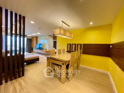 Spacious modern living and dining area with stylish decor and bright yellow accent wall.