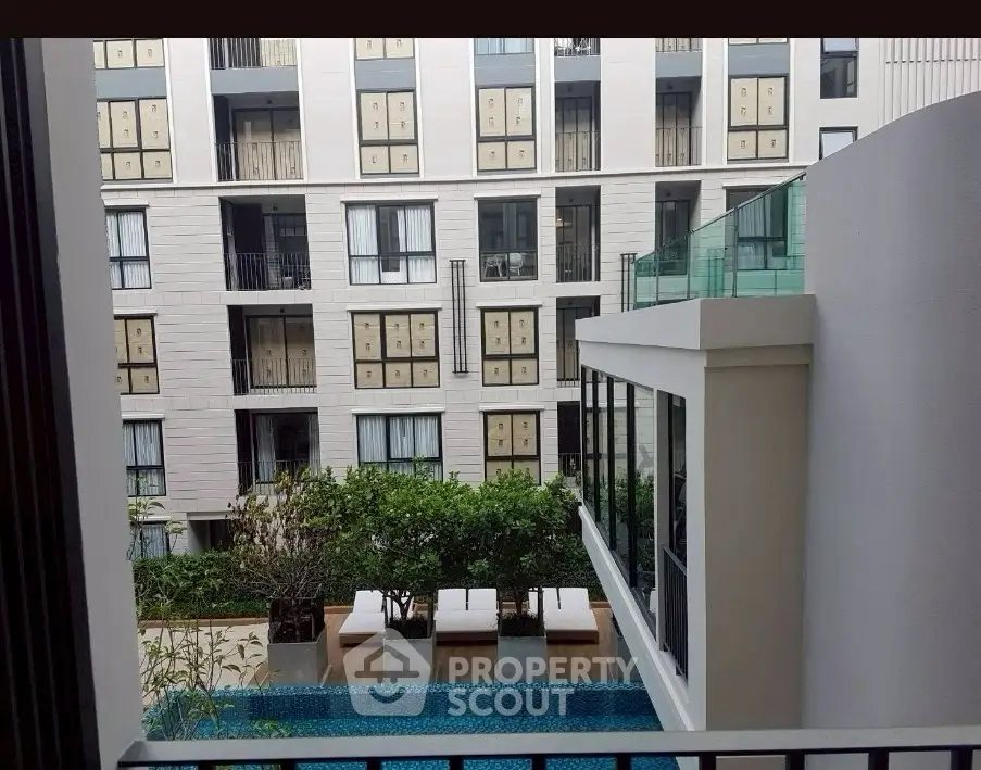 Modern apartment building with pool view and lush greenery