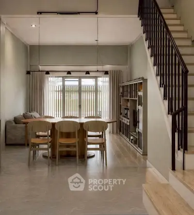 Spacious modern living room with dining area and staircase, featuring elegant decor and natural light.
