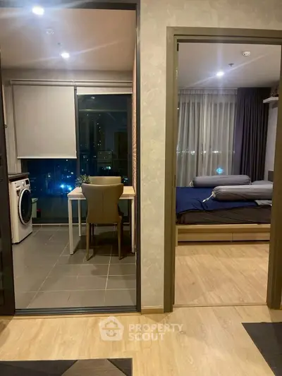 Modern apartment interior with cozy bedroom and compact laundry area.