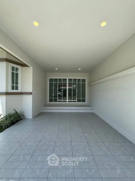 Spacious covered patio with tiled flooring and modern sliding glass doors.