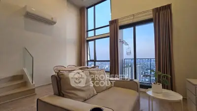 Modern living room with high ceilings and city view, featuring cozy seating and elegant decor.