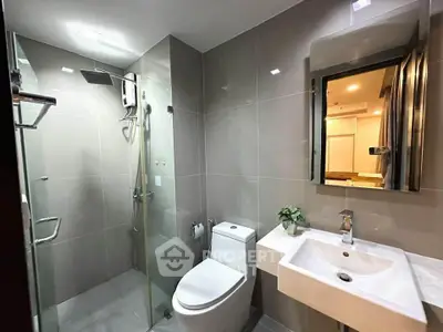 Modern bathroom with sleek design, featuring glass shower and contemporary fixtures.