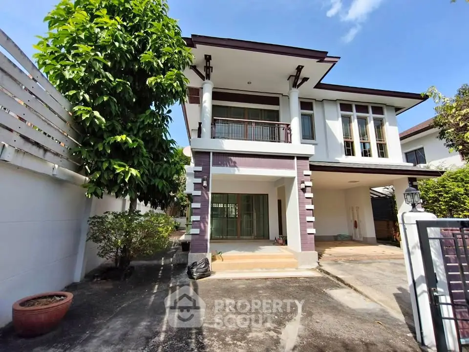 Charming two-story house with spacious driveway and lush greenery, perfect for family living.