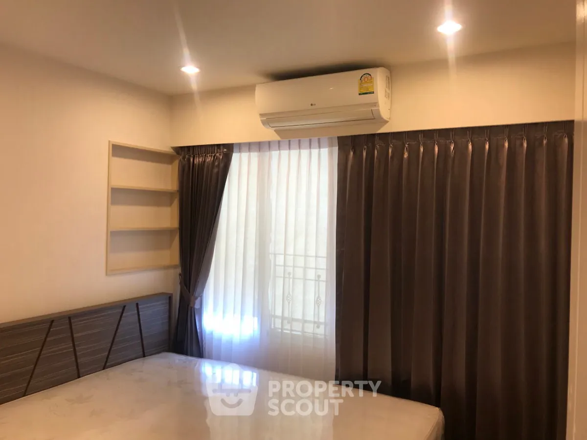 Cozy bedroom with air conditioning and elegant curtains, perfect for restful nights.