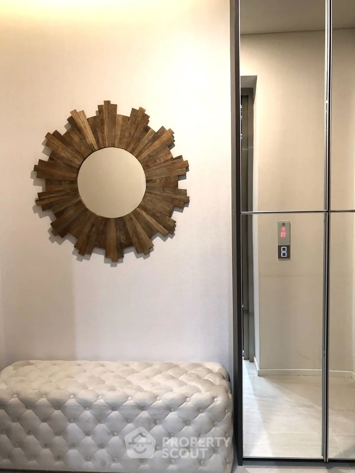 Stylish elevator lobby with modern decor and unique mirror design.