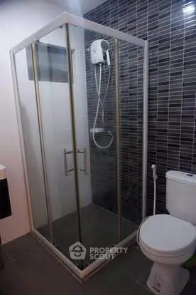 Modern bathroom with glass shower enclosure and sleek tile design.