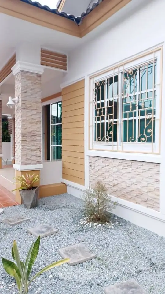 Charming exterior of a modern home with stone accents and landscaped garden.