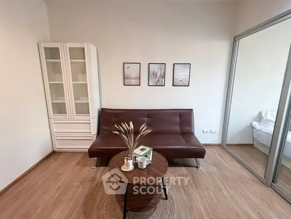 Modern living room with sleek brown sofa, stylish decor, and wooden flooring, perfect for cozy relaxation.