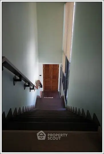 Elegant staircase with wooden steps leading to a stylish entrance door.