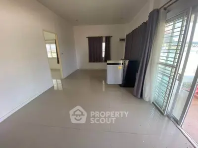 Spacious living room with large windows and modern tile flooring, perfect for natural light and open living.