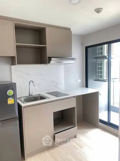 Modern kitchen with sleek cabinetry and balcony view in a stylish apartment