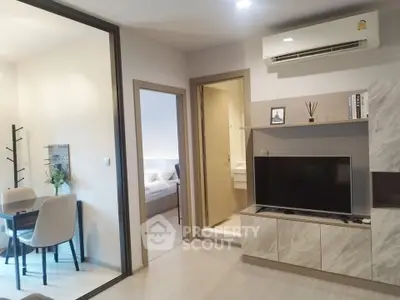 Modern apartment interior with open living room, dining area, and bedroom view.