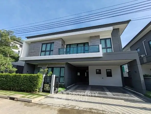 Modern two-story house with spacious driveway and lush greenery