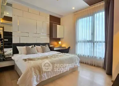 Luxurious bedroom with modern decor and large window offering natural light