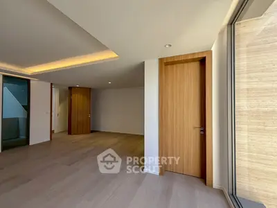 Spacious modern living room with wooden flooring and large windows