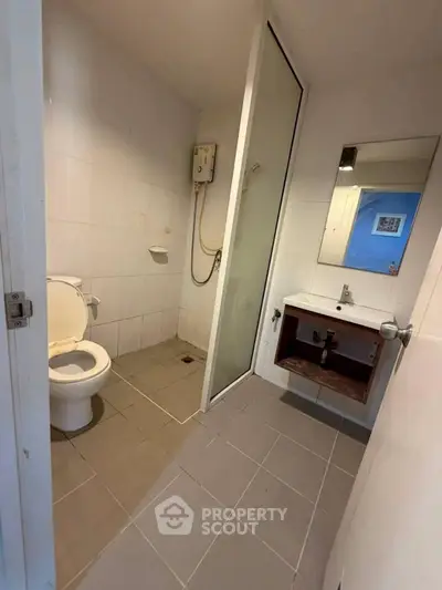 Compact bathroom with shower and modern fixtures in a real estate property.