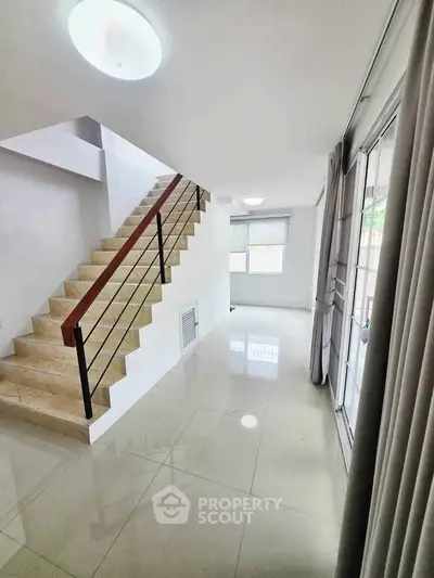Modern interior with sleek staircase and bright open space, perfect for contemporary living.