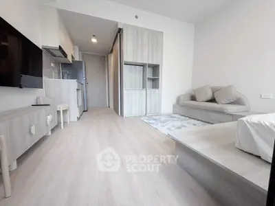 Modern living room with sleek furniture and open kitchen layout in stylish apartment.