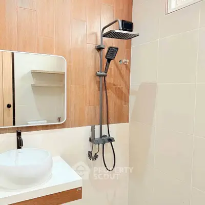 Modern bathroom with sleek showerhead and stylish sink in contemporary design.