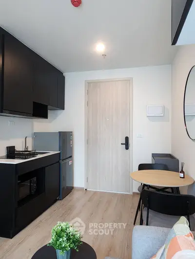 Modern compact apartment with sleek kitchen and cozy dining area