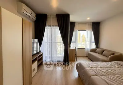 Modern bedroom with city view, featuring stylish decor and natural light.