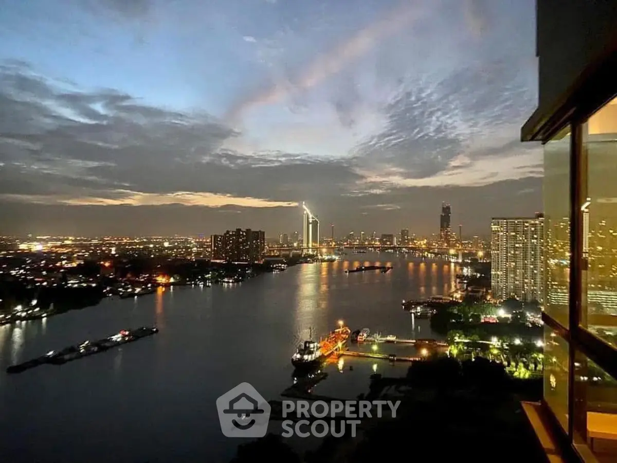 Stunning cityscape view from high-rise apartment overlooking river at dusk.