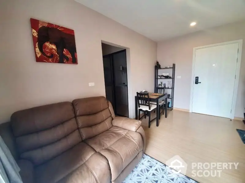 Spacious living room with modern furnishings, sleek hardwood flooring, and a warm neutral color palette, perfect for relaxation or entertaining guests.