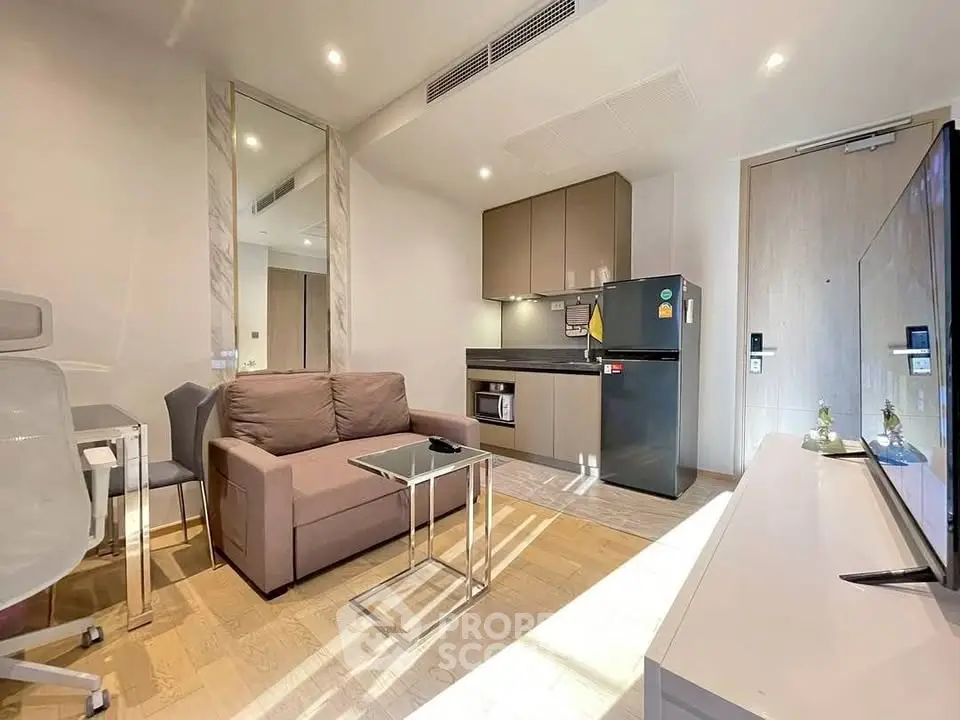 Modern living room with sleek furniture and compact kitchen in a stylish apartment.