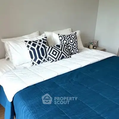 Modern bedroom with stylish geometric pillows and cozy blue bedding