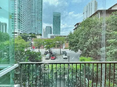 Urban balcony view with high-rise buildings and lush greenery, perfect for city living enthusiasts.
