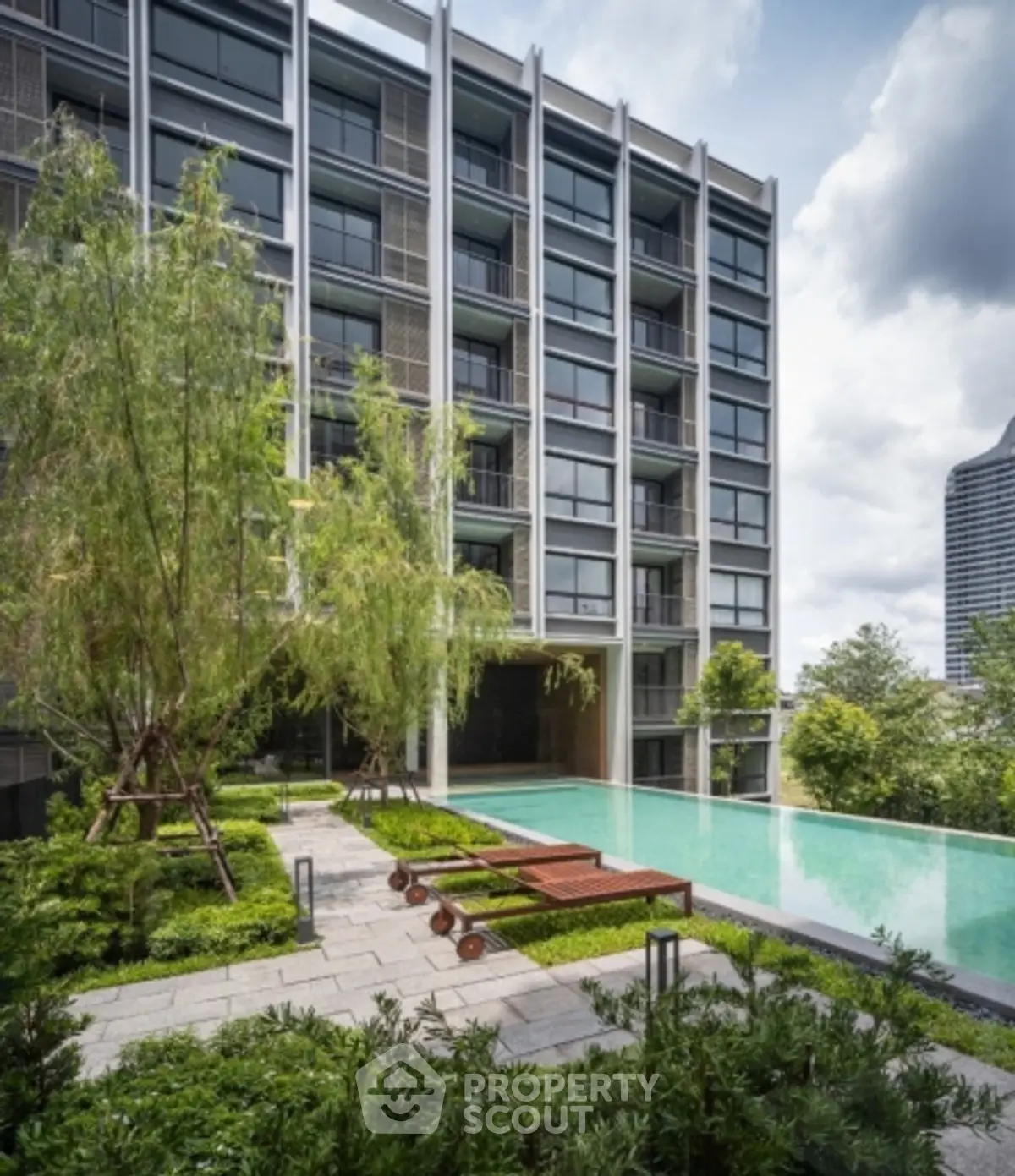 Luxurious modern apartment building with stunning pool and lush greenery