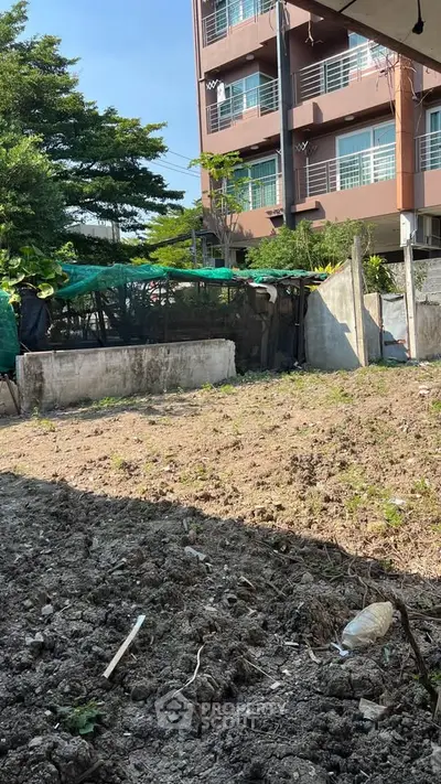 Vacant land plot with potential for development near urban residential building.