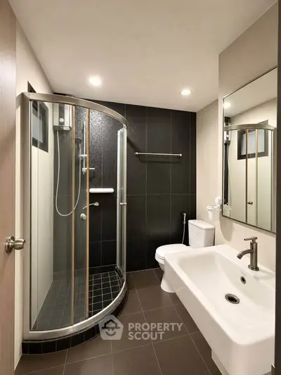 Modern bathroom with sleek shower and elegant fixtures in a contemporary apartment.