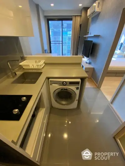 Modern compact kitchen with integrated washing machine and city view