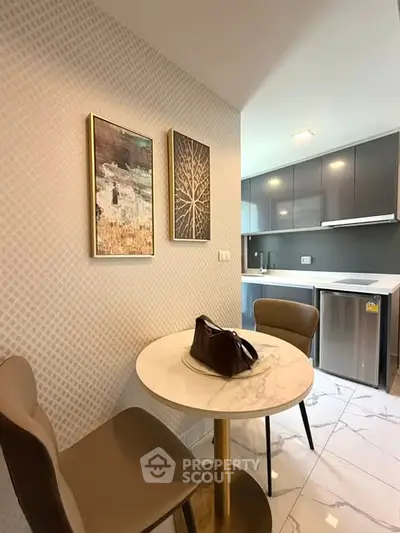 Modern kitchen with sleek cabinets and cozy dining area in stylish apartment.