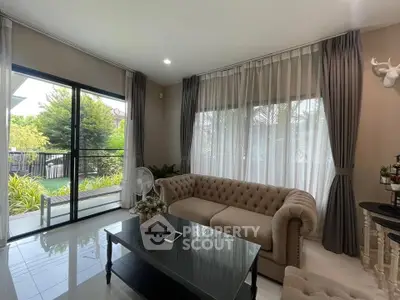 Elegant living room with plush sofa, large windows, and garden view, perfect for relaxation and entertaining.