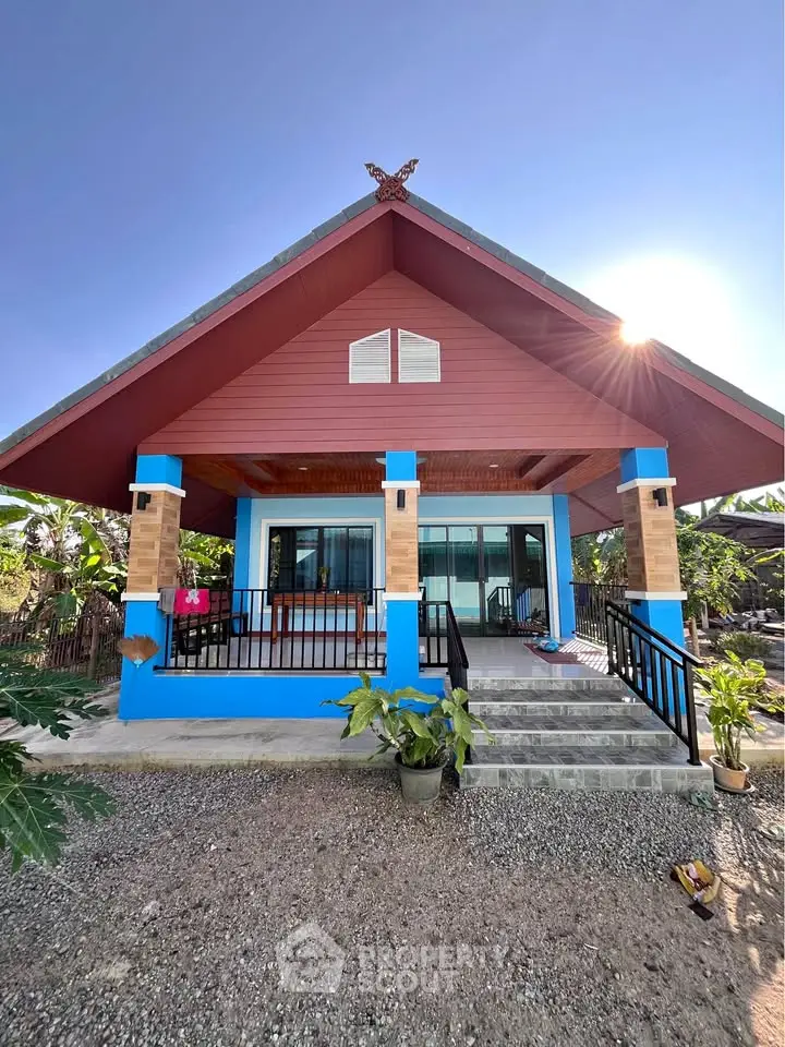 Charming single-story house with vibrant blue accents and inviting front porch.