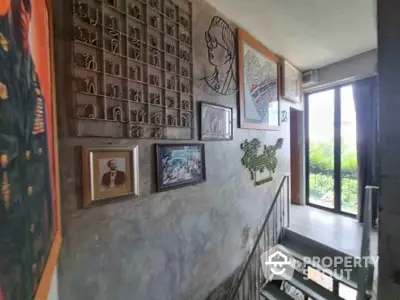 Artistic stairway with unique wall decor and large window view